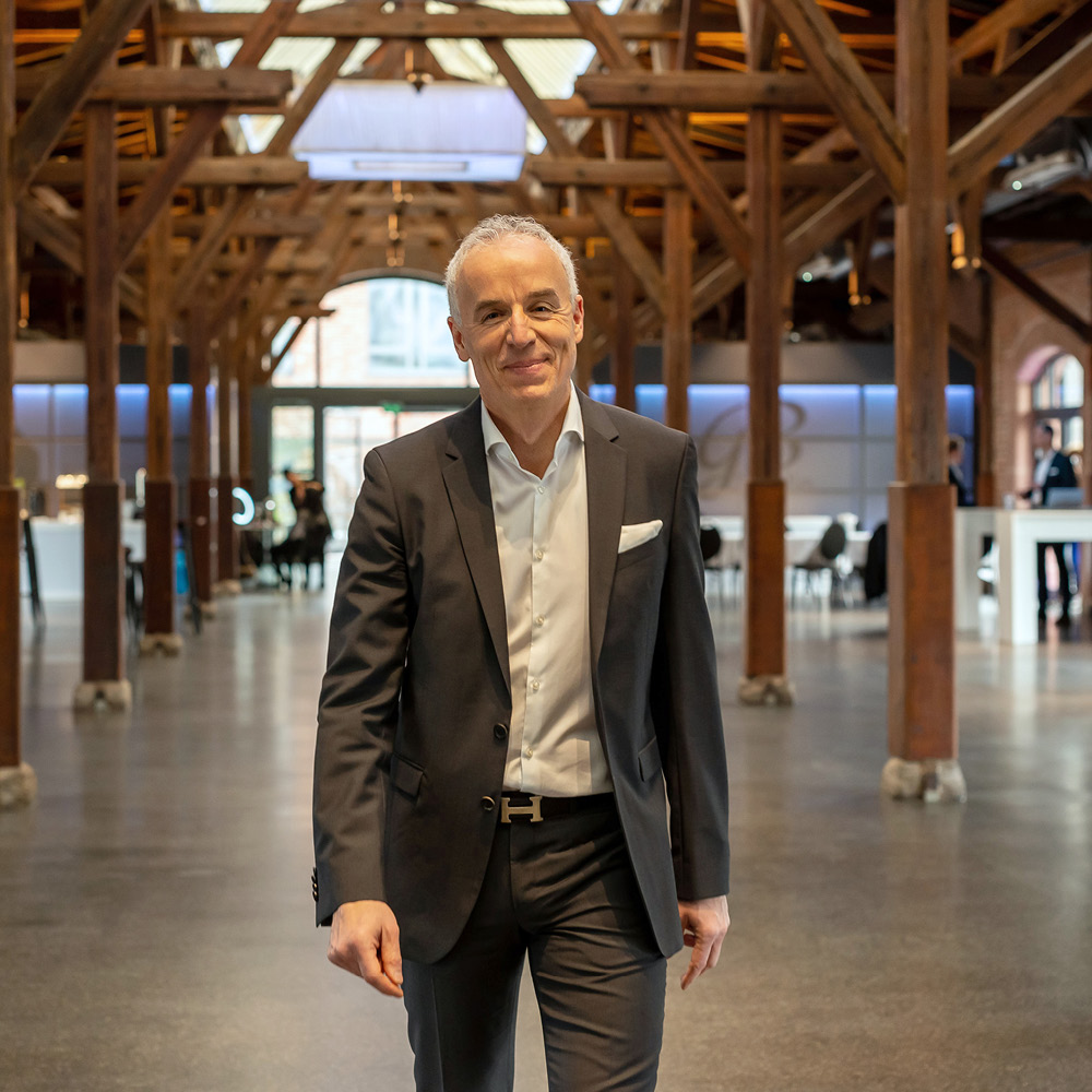 Das Bild zeigt TBF Senior Fondsmanager Roman Kostal auf einen zu laufend in der Eventlocation Güterbahnhof in Bad Homburg